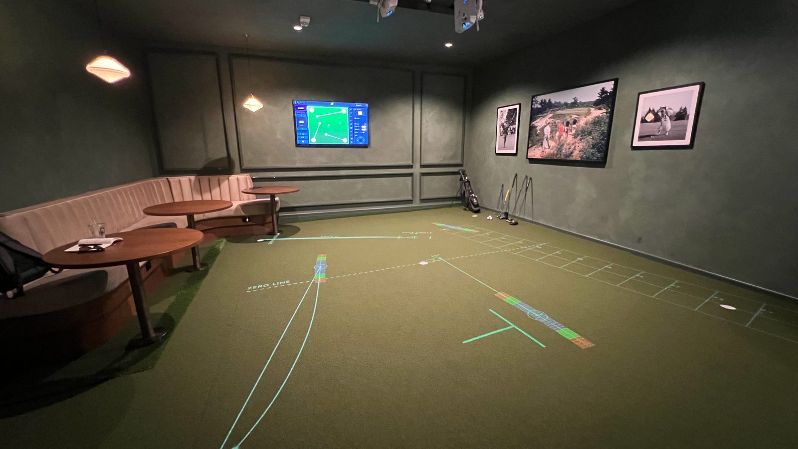 Intown Golf Columbus: a putting studio with projected putting lines and booth seating