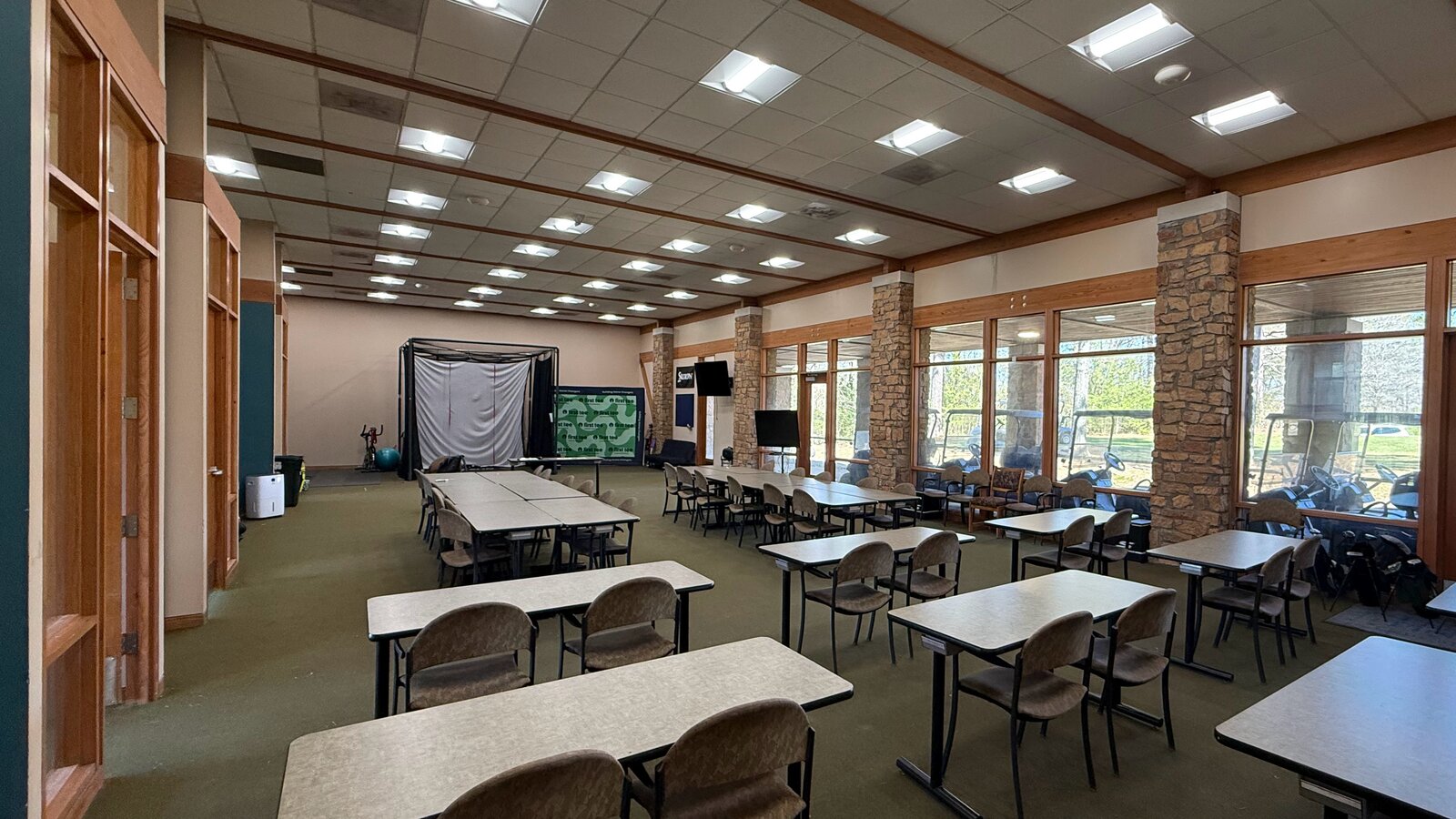 Before: a classroom with rows of tables and chairs, and a hitting net at the far end