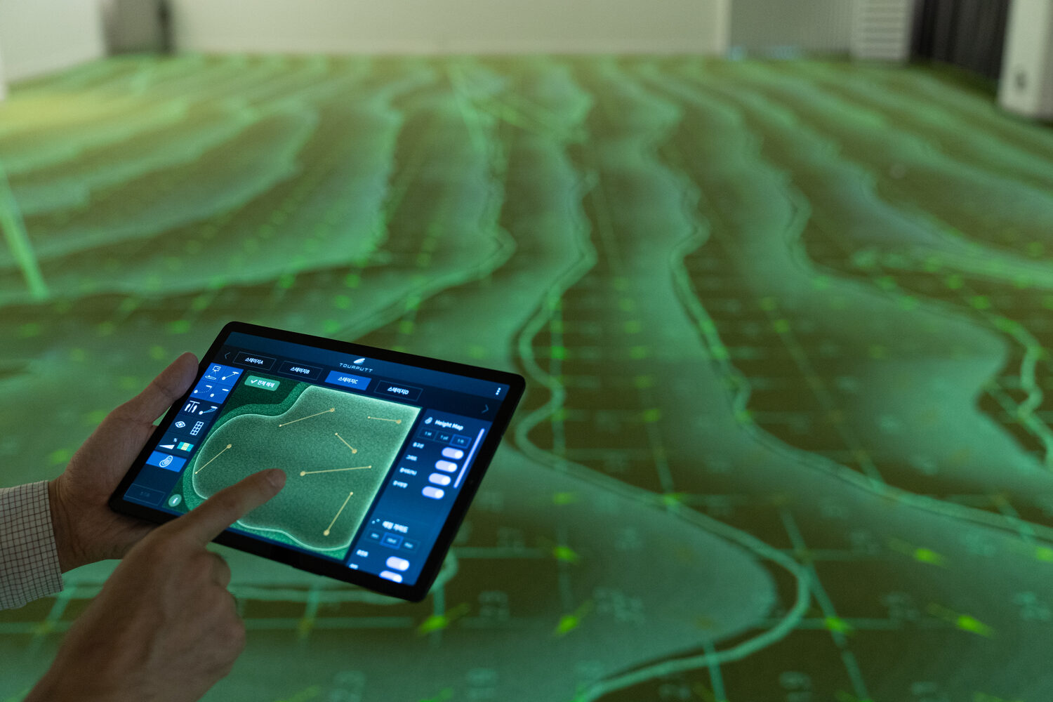 A height map of the green projected as contour lines, with a tablet held in the foreground