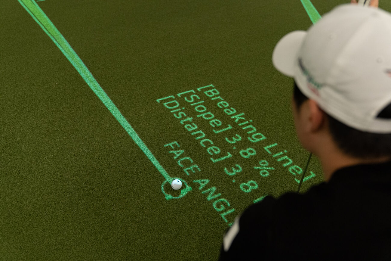 A golfer reads a putt with the breaking line, a slope of 3.8 percent and the distance projected on the green beside the ball